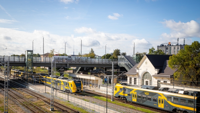 Augšas skats uz modernizēto elektrificēto dzelzceļa infrastruktūra Zemitānu stacijā. Redzams Vivi vilciens, stacijas ēka, sliedes