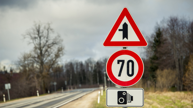 ceļa zīmes uz autoceļa fona