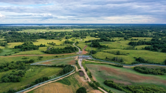 LAU Infra Grupa AS drona foto, kurā redzams ceļš, kas iet cauri Latvijas zaļiem laukiem vasarā