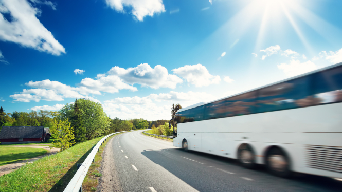 autobuss brauc par autoceļu saulainā vasaras dienā