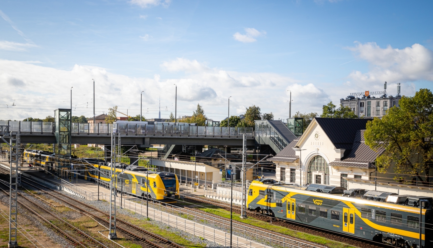 Augšas skats uz modernizēto elektrificēto dzelzceļa infrastruktūra Zemitānu stacijā. Redzams Vivi vilciens, stacijas ēka, sliedes