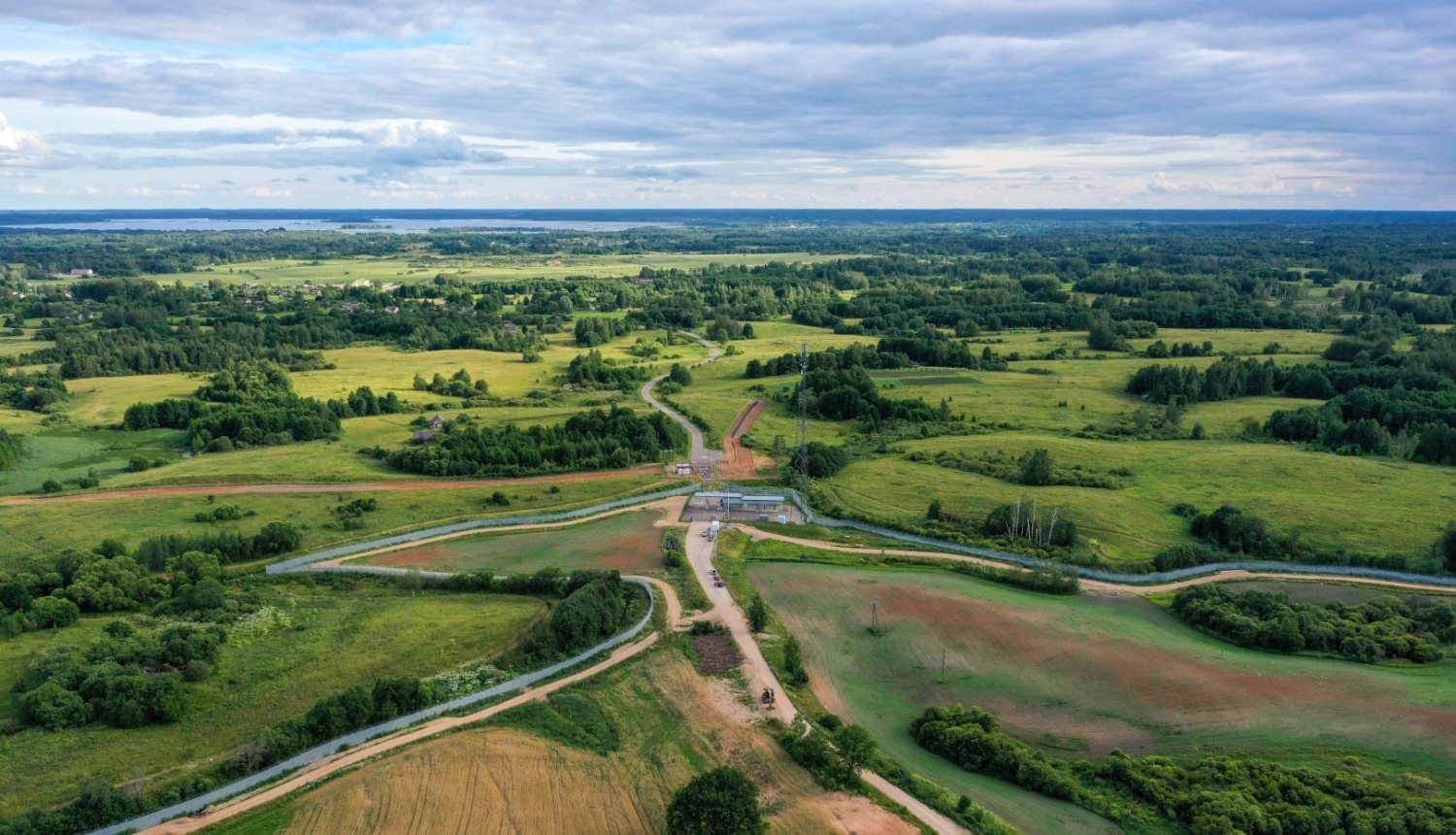 LAU Infra Grupa AS drona foto, kurā redzams ceļš, kas iet cauri Latvijas zaļiem laukiem vasarā