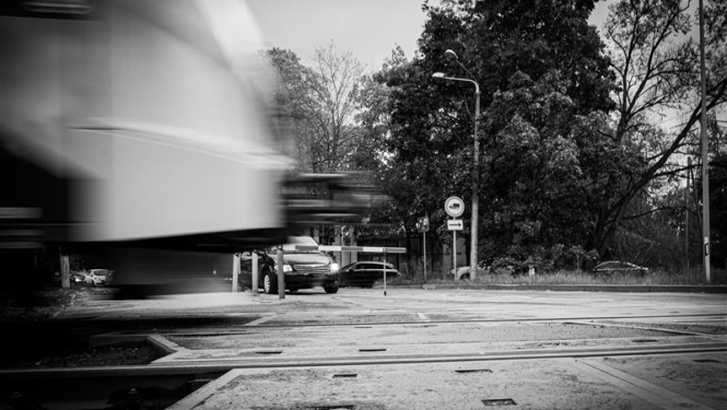 Dzelzceļa pārbrauktuve. Vilciens brauc, automašīnas stāv.