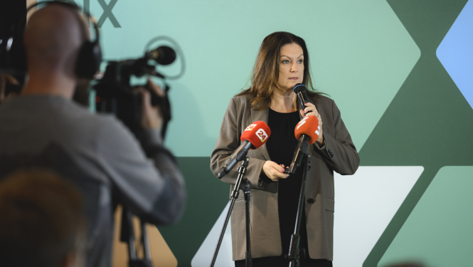 RIX Rīgas lidosta telpās tiek prezentāts plāns, prezentētāja stāv pie mediju mikrofoniem