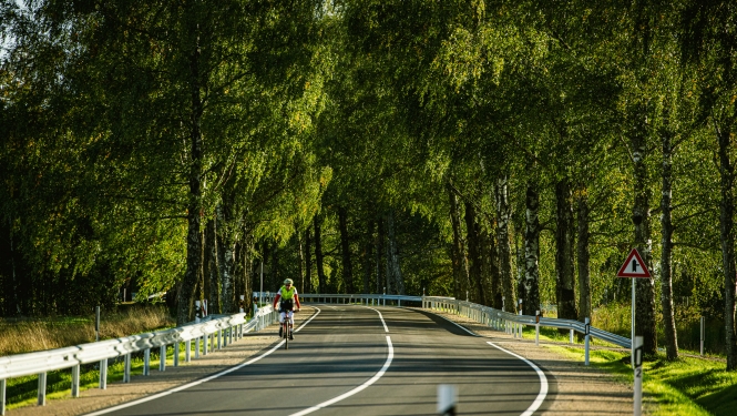 velosipēdists uz autoceļa vasaras dienā