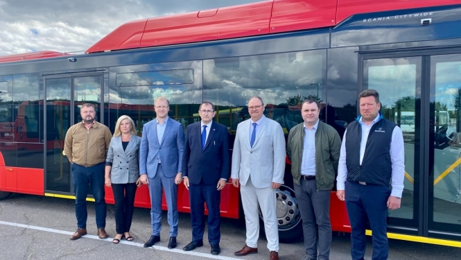 cilvēku grupa pie autobusa