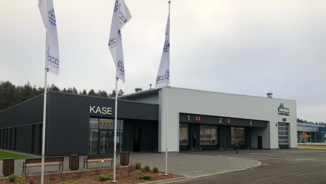 CSDD ēka nofotografēta no ārpuses. Redzama kase, iebrauktuves, invalīdu parkošanās vietas