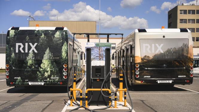 RIX Rīgas lidosta, kurā stāv divi pasažieru autobusi ar RIX zīmola apdruku