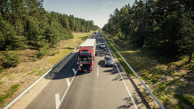 kravas auto un vieglais auto uz šosejas vasarā
