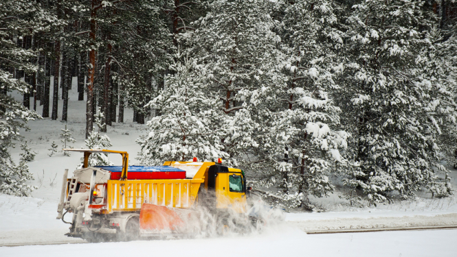 Sniega tīrītājs ziemā tīra ceļu no sniega segas