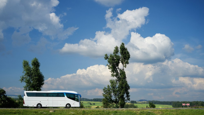 autobuss lauku ainavā saulainā dienā