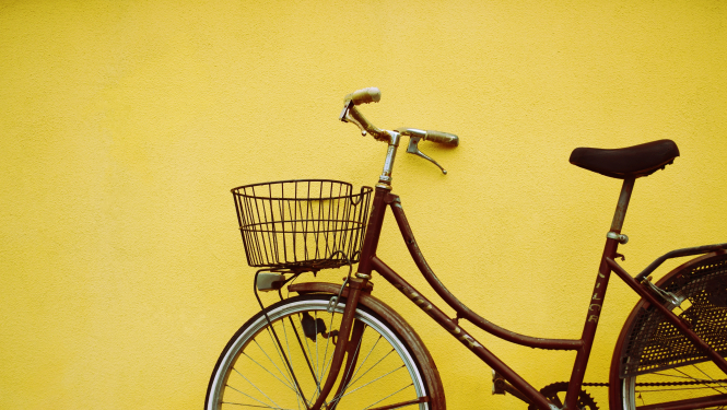 velosipēds pie dzeltenas sienas
