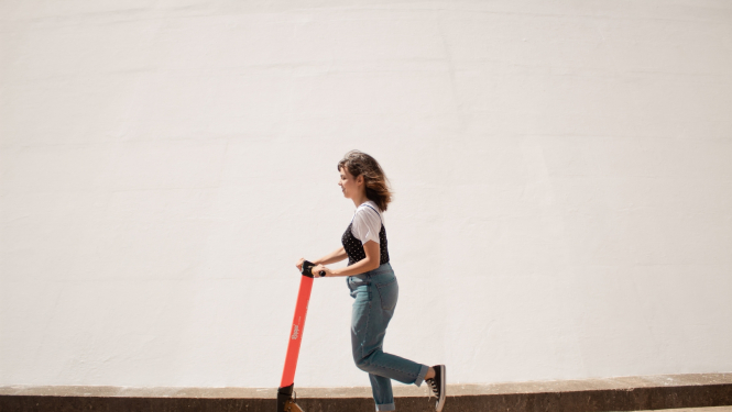 sieviete uz elektriskā skrejriteņa