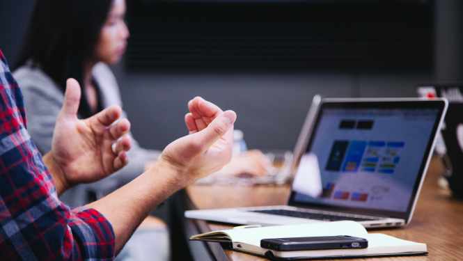 skats uz rokām pie datorgalda