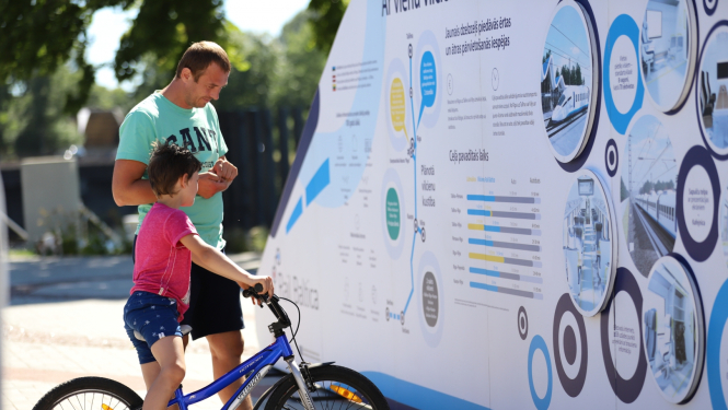 vīrietis un zēns aplūko izstādi