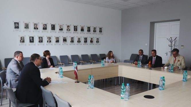 cilvēki sēž ap galdu