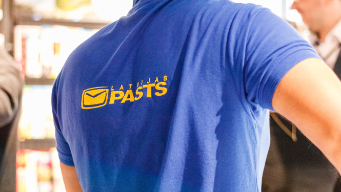 Latvijas Pasta darbinieks uzņēmuma kreklā