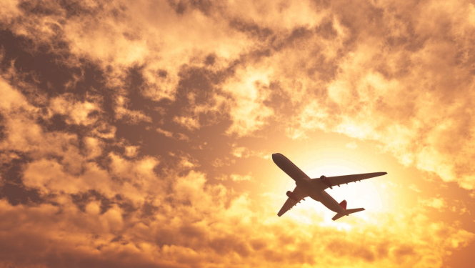 lidomašīna saulrieta mākoņos