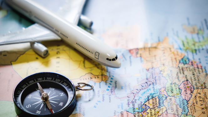 lidmašīnas modelis un kompass uz pasaules kartes