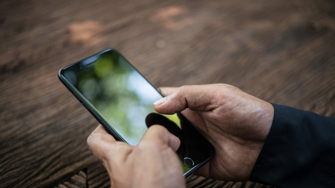 telefons vīrieša rokās