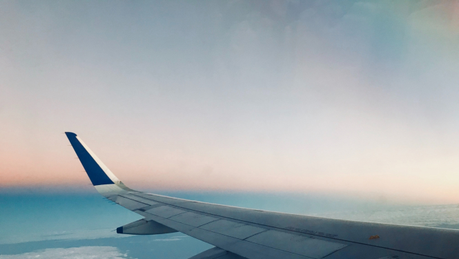 lidmašīnas spārns uz zila fona