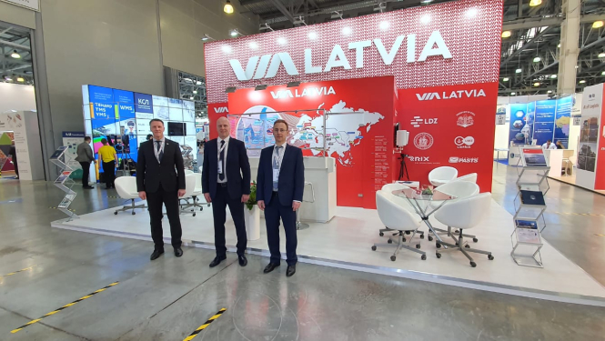 trīs vīrieši pie ViaLatvia stenda