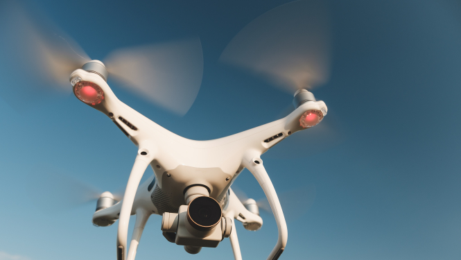 balts drons uz debesu fona