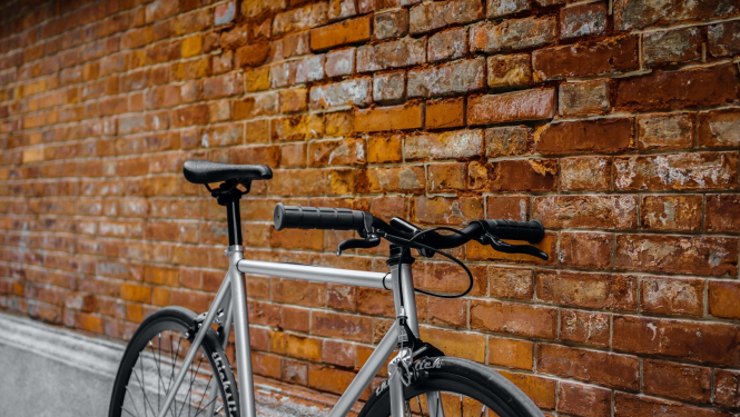 pret ķieģeļu sienu atstutēts velosipēds
