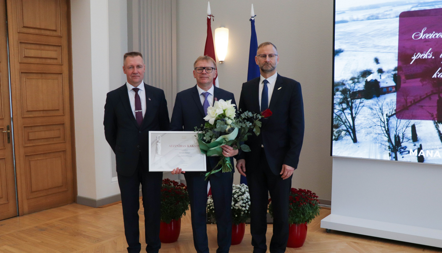 ministrs Atis Švinka un valsts sekretārs Andulis Židkovs sveic Ģirtu Ozolu