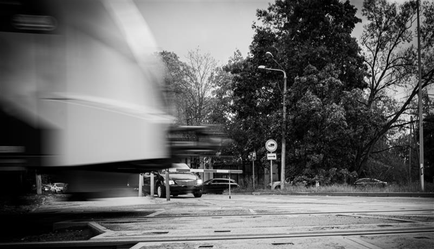 Dzelzceļa pārbrauktuve. Vilciens brauc, automašīnas stāv.