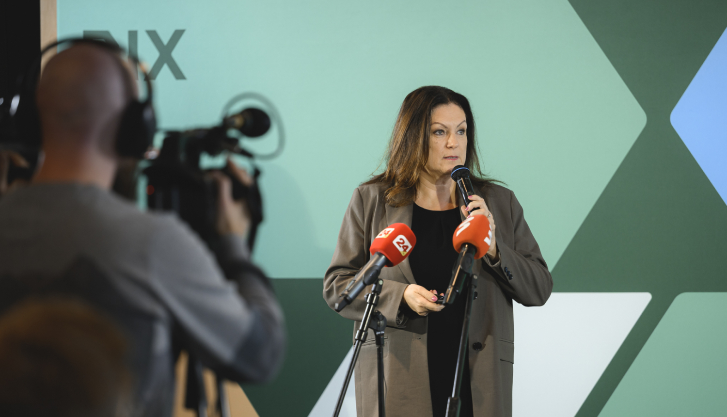 RIX Rīgas lidosta telpās tiek prezentāts plāns, prezentētāja stāv pie mediju mikrofoniem