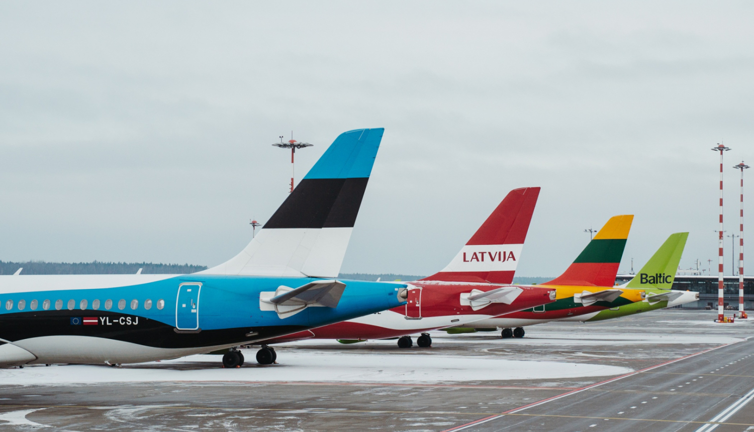 RIX Rīgas lidosta, kurā redzamas 4 lidmašīnu astes ar Baltijas valstu karogu apdruku un viena - airBaltic