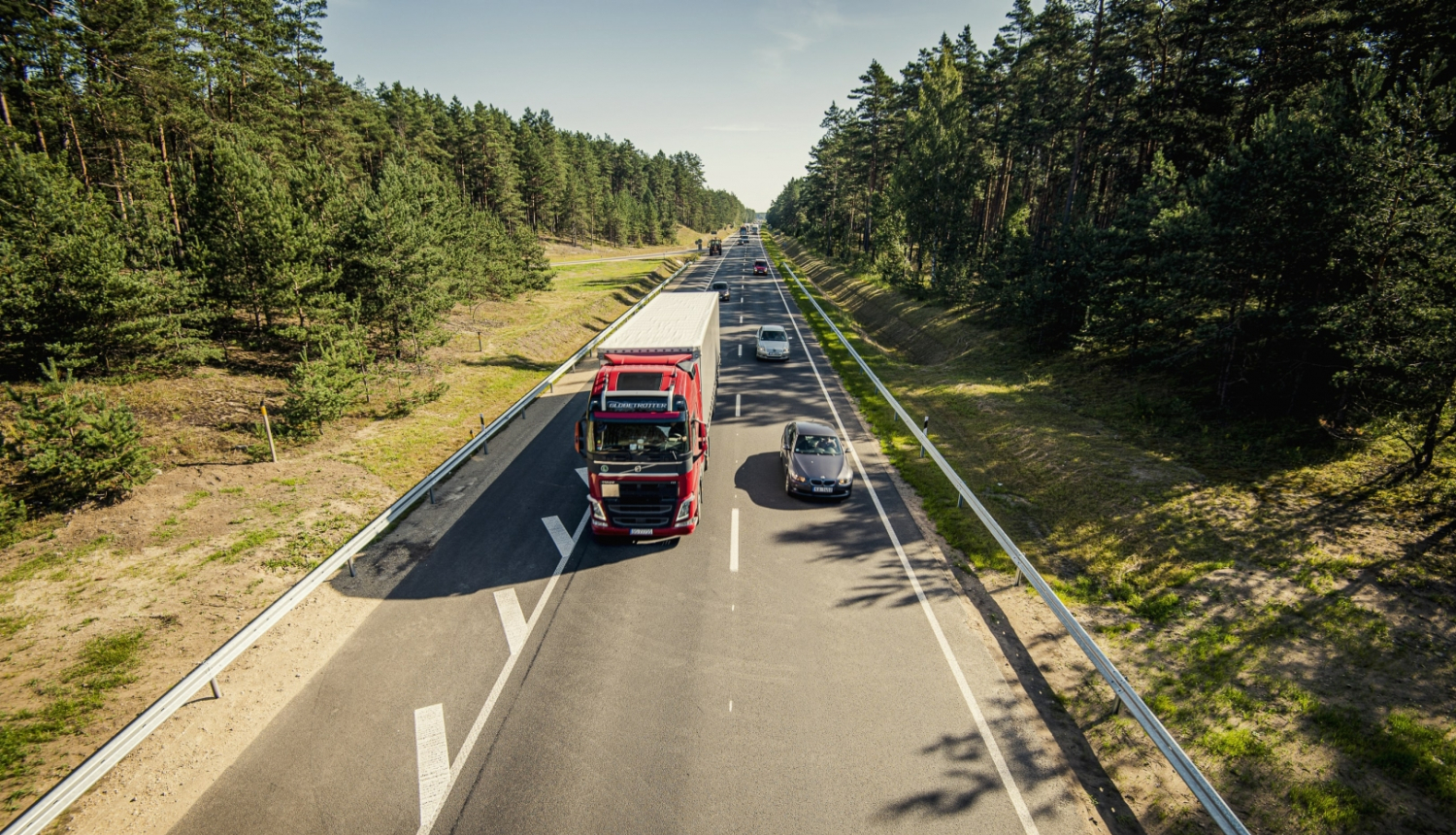 kravas auto un vieglais auto uz šosejas vasarā