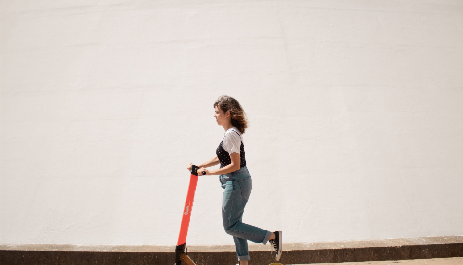 sieviete uz elektriskā skrejriteņa