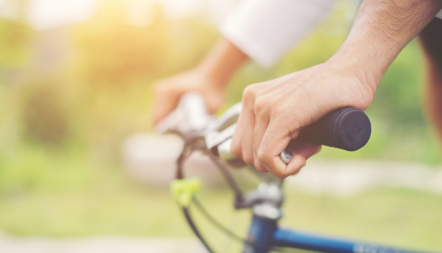 sievietes rokas uz velosipēda stūres