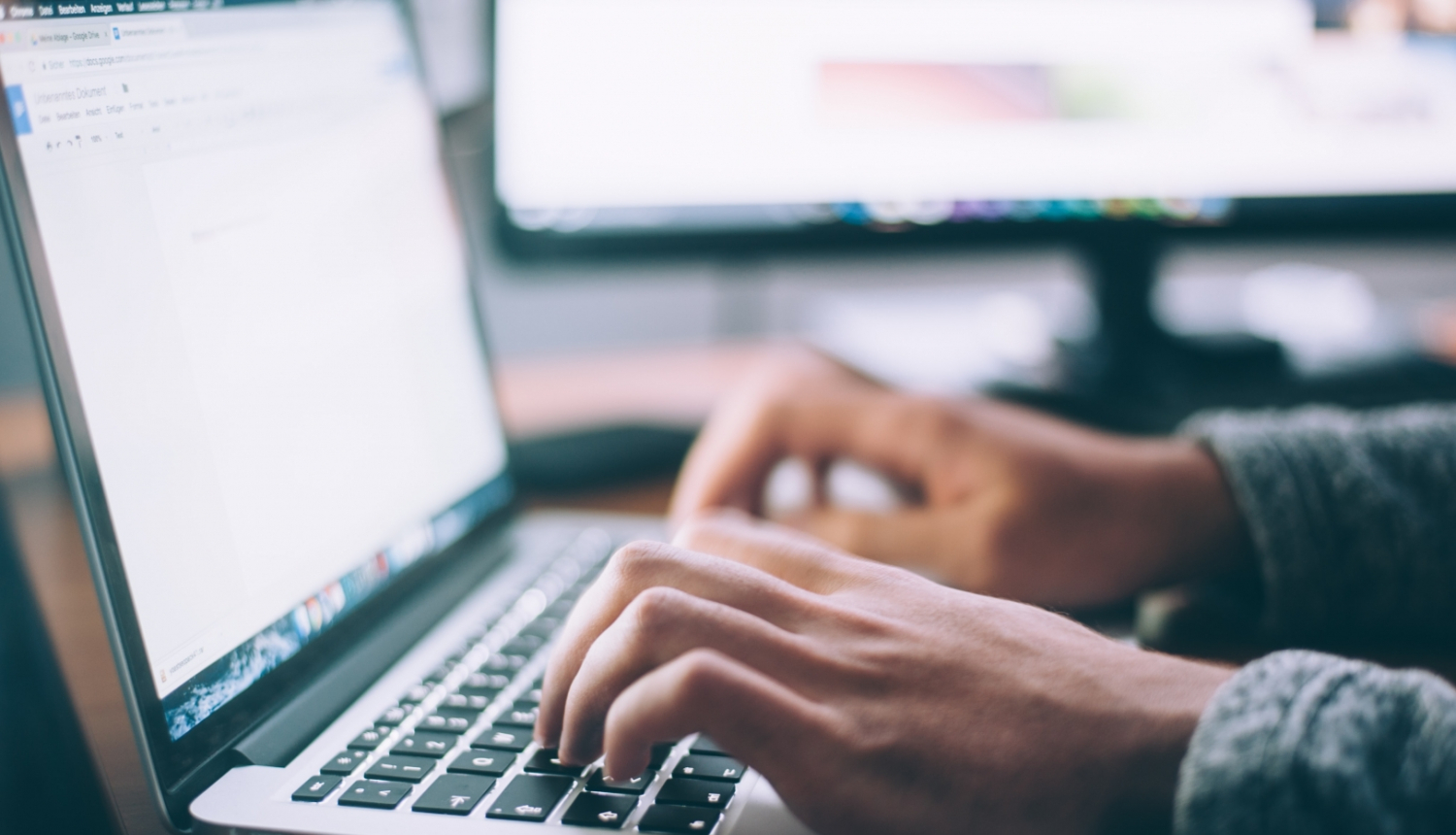 tuvplāns ar rokām pie portatīvā datora