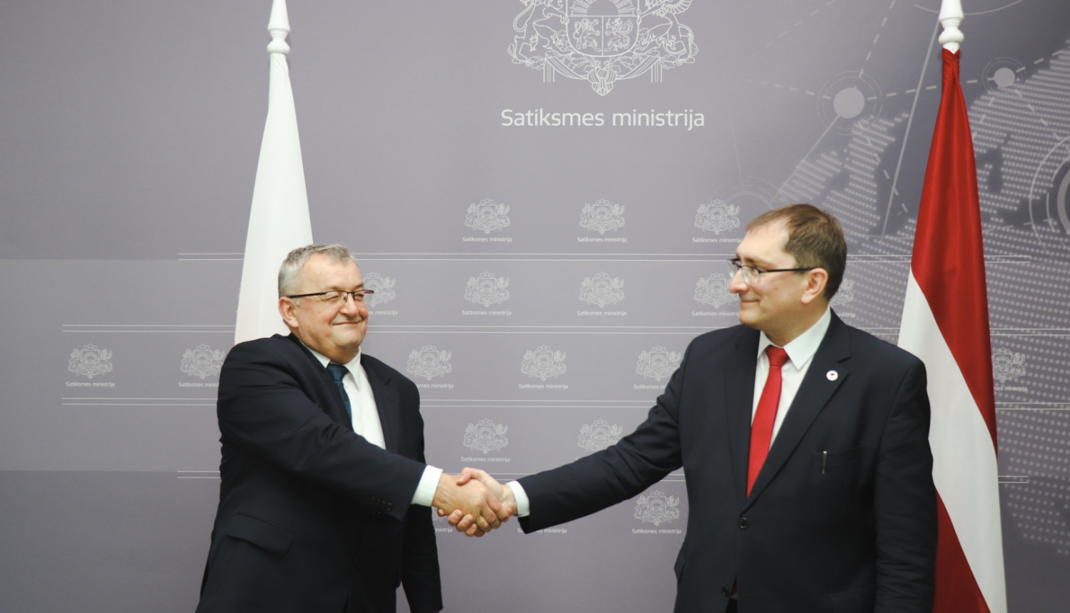 Polijas infrastruktūras ministrs Andžejs Adamčiks un Latvijas satiksmes ministrs Tālis Linkaits sarokojas
