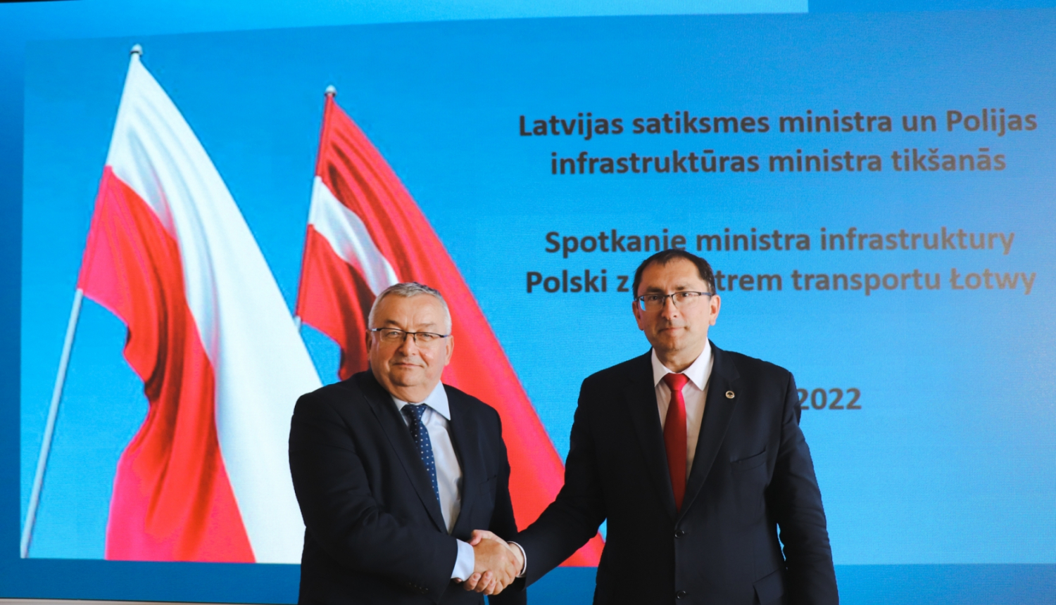 Polijas infrastruktūras ministrs Andžejs Adamčiks un Latvijas satiksmes ministrs Tālis Linkaits sarokojas