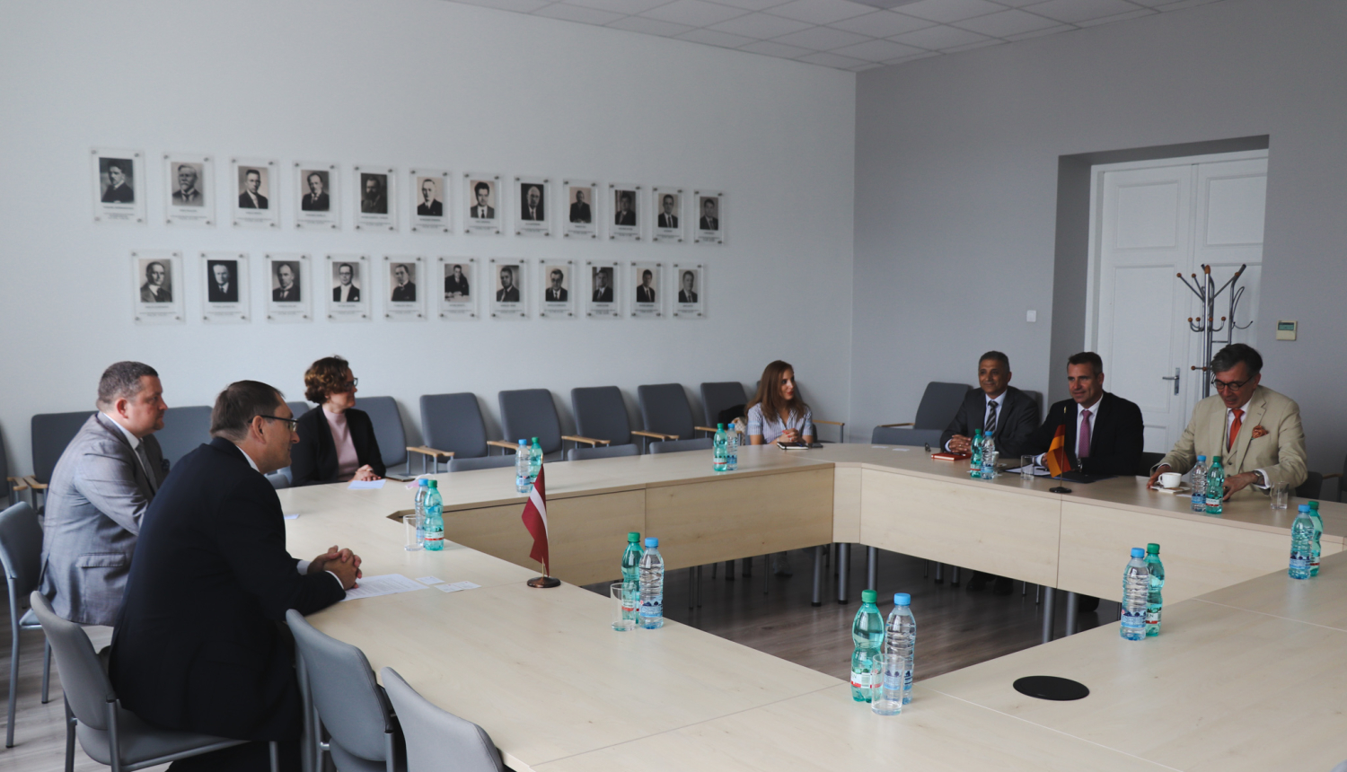 cilvēki sēž ap galdu