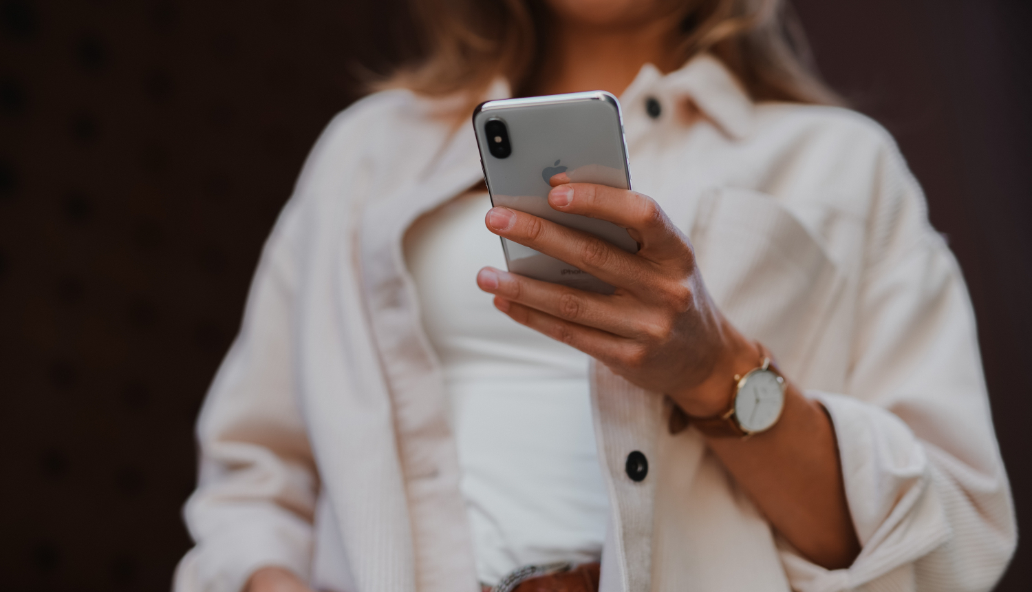 sieviete tur rokās viedtālruni