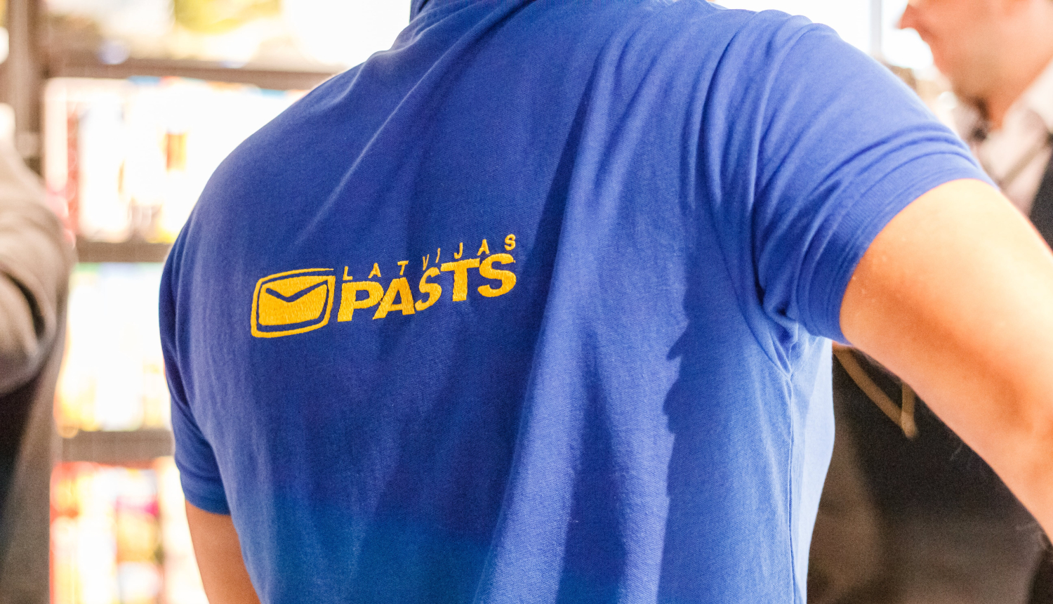 Latvijas Pasta darbinieks uzņēmuma kreklā