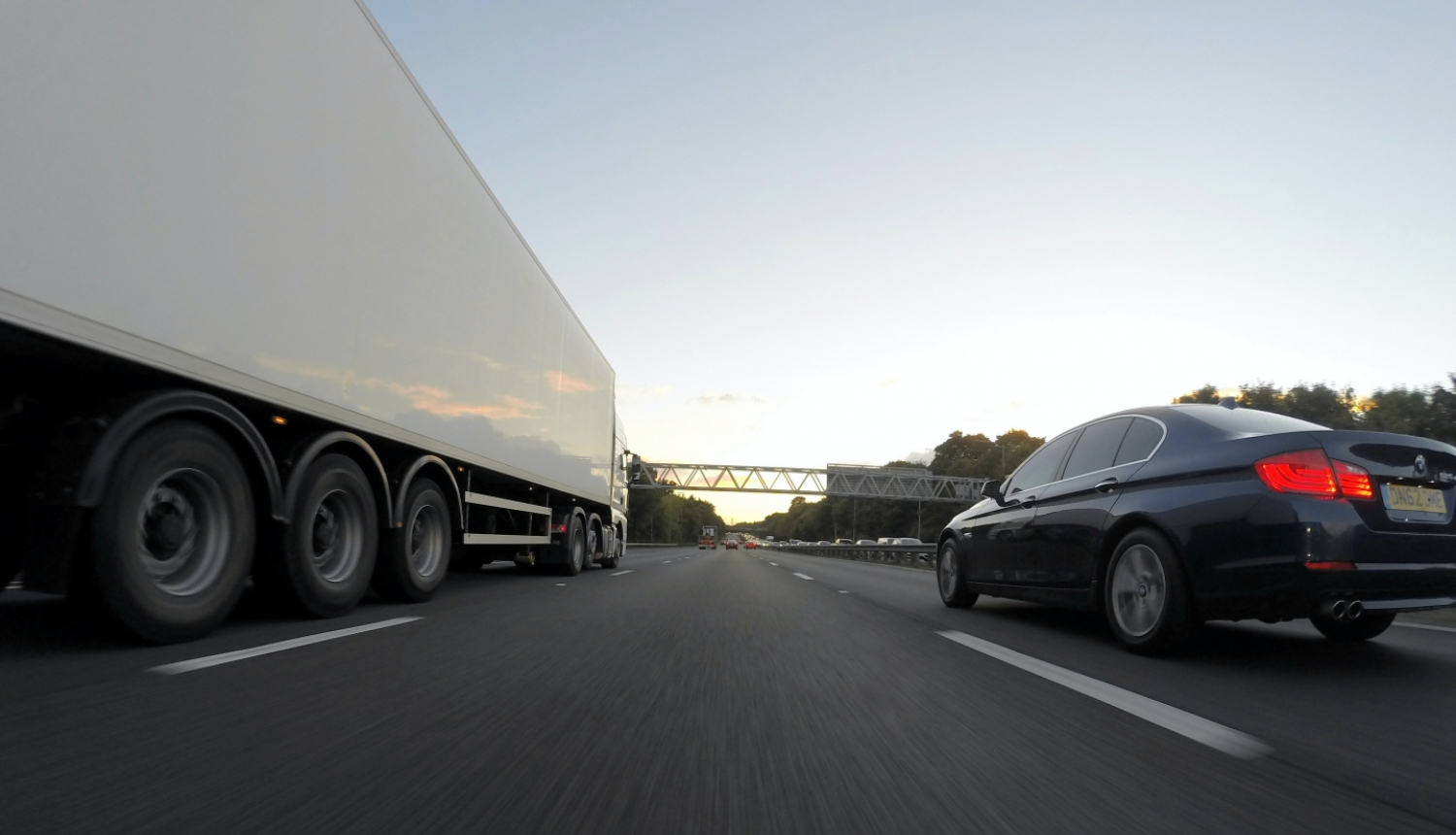 kravas auto un vieglais auto uz šosejas