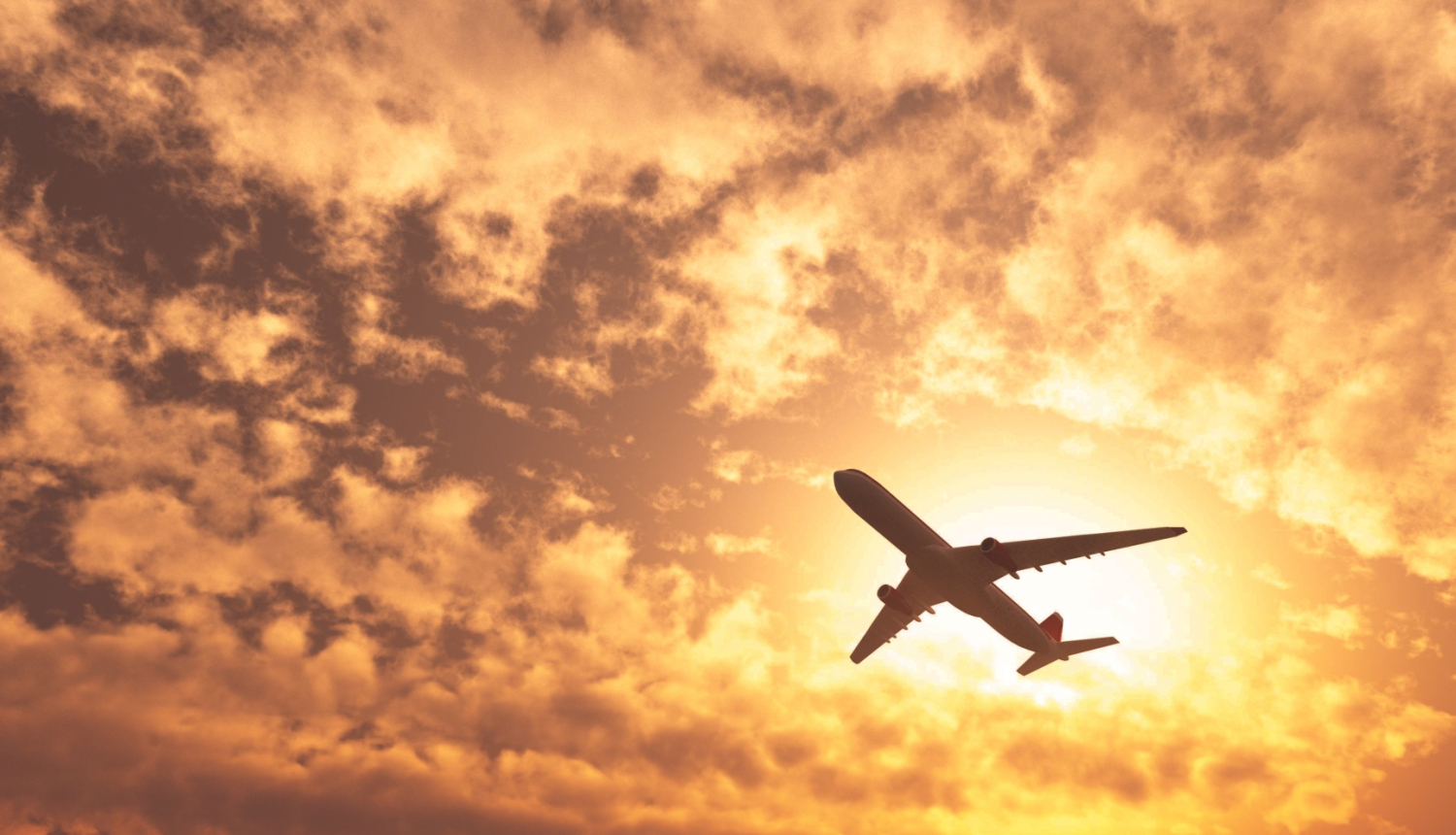 lidmašīna uz saulrieta debesīm