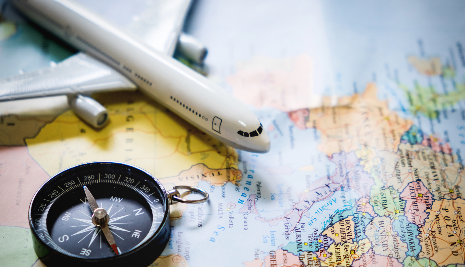 lidmašīnas modelis un kompass uz pasaules kartes