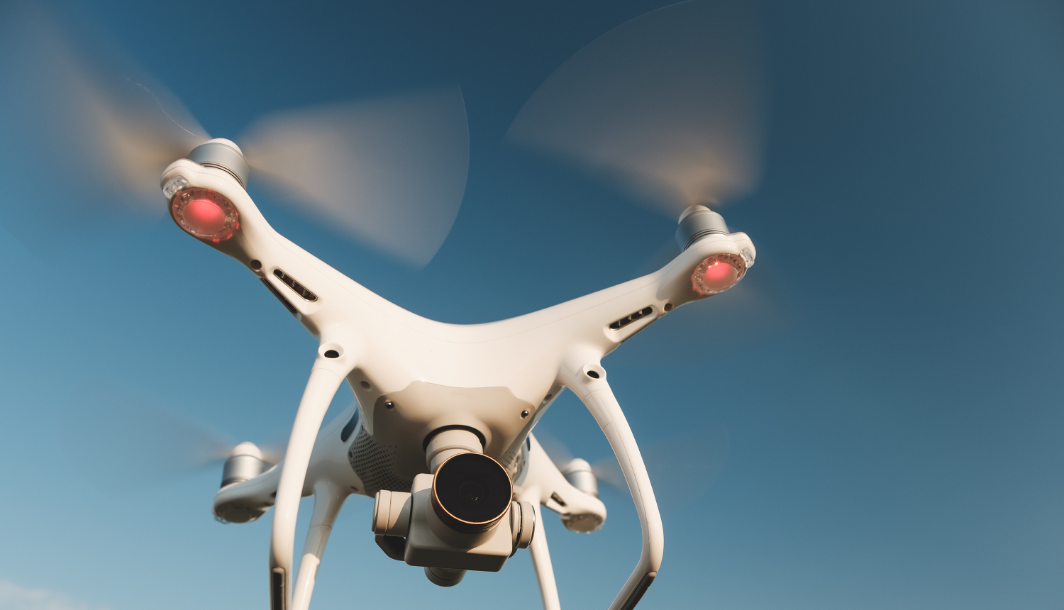 balts drons uz debesu fona