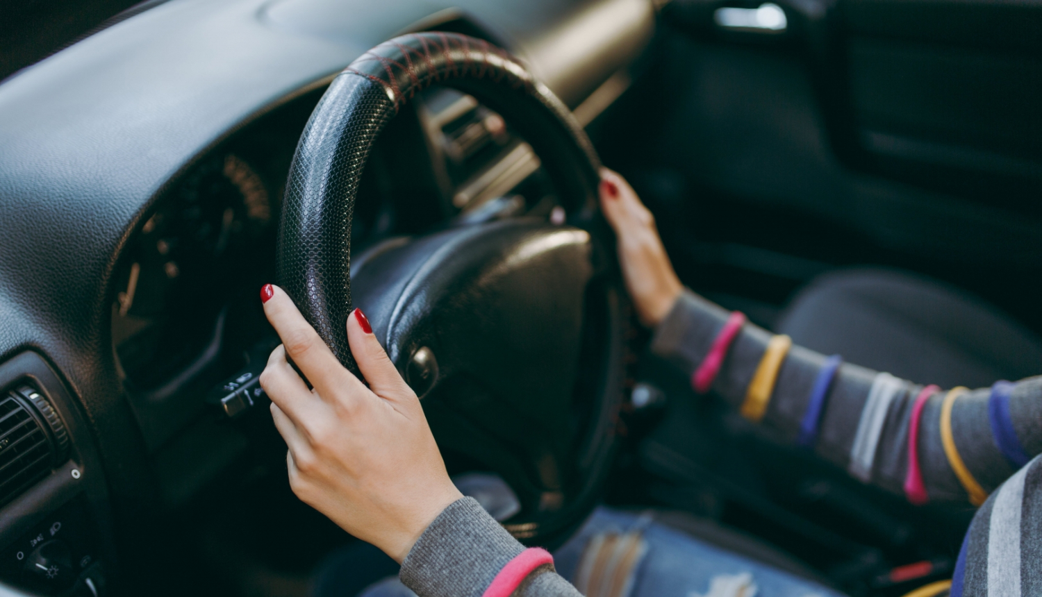 sievietes rokas uz stūres