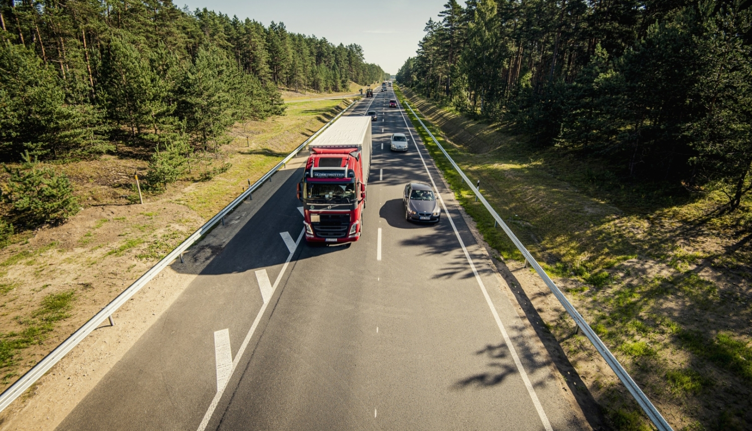 kravas auto un vieglais auto uz šosejas vasarā