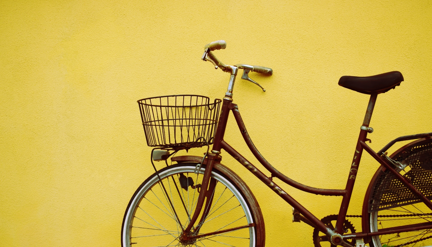 velosipēds pie dzeltenas sienas