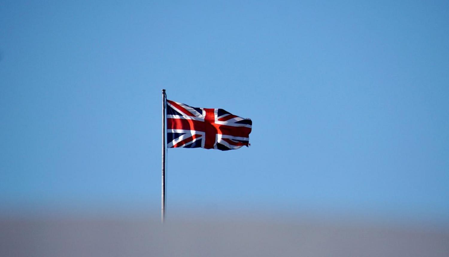 Lielbritānijas karogs uz gaišzilu debesu fona